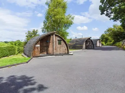 a large wooden barn and a barn house at Pod2 - Powys River Pods - Pet Friendly Glamping Pod Builth Wells Powys Wales in Garth