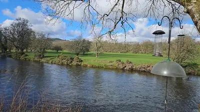 a view of a river with a dome in the foreground at Pod2 - Powys River Pods - Pet Friendly Glamping Pod Builth Wells Powys Wales in Garth