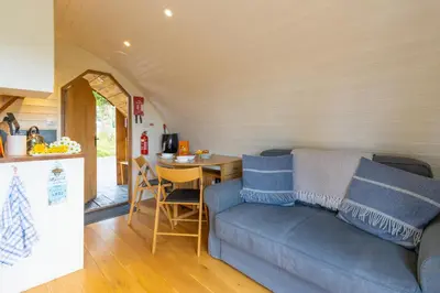 a living room with a couch and a table at Pod1 - Powys River Pods - Pet Friendly Glamping Pod Builth Wells Powys Wales in Garth