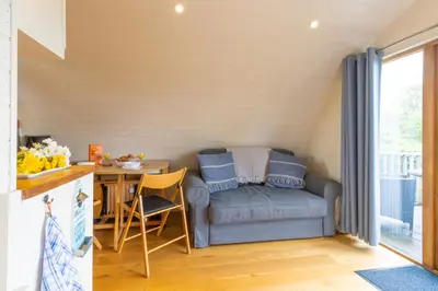 a living room with a couch and a table at Pod1 - Powys River Pods - Pet Friendly Glamping Pod Builth Wells Powys Wales in Garth
