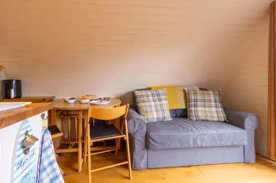 a kitchen with a couch and a table with a chair at Pod3 - Powys River Pods - Pet Friendly Glamping Pod Builth Wells Powys Wales in Garth