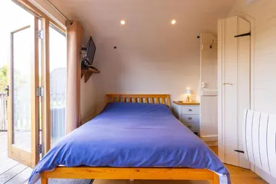 a bed in a room with a large window at Pod3 - Powys River Pods - Pet Friendly Glamping Pod Builth Wells Powys Wales in Garth