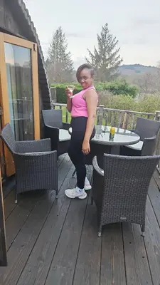 a woman standing on a deck with a table at Pod3 - Powys River Pods - Pet Friendly Glamping Pod Builth Wells Powys Wales in Garth