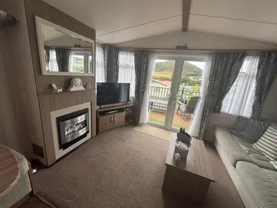 a living room with a couch and a fireplace at Green Heaven at Clarach Bay Spacious 3 BedPet Friendly Luxury Steps from the Sea in Aberystwyth