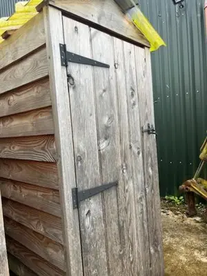 a wooden door on the side of a fence at Tinkers Horn Cabin in Kington