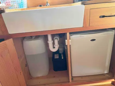 a cabinet with a sink and a refrigerator underneath it at Tinkers Horn Cabin in Kington
