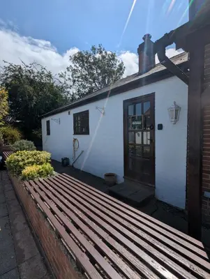 a white house with a wooden deck in front of it at Breidden Annexe in Four Crosses