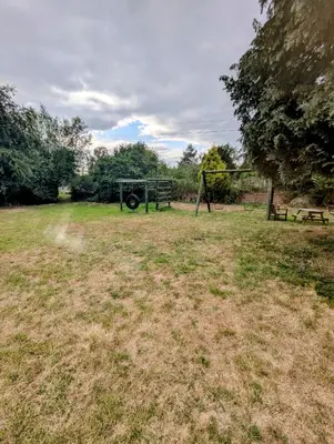 an empty field with a swing set in a park at Breidden Annexe in Four Crosses