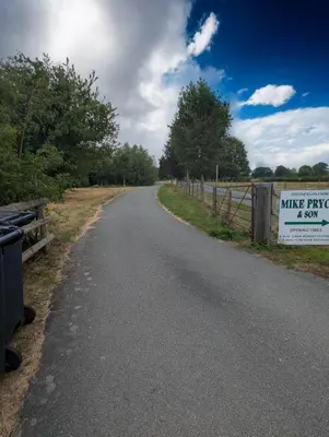 an empty road with a sign on a fence at Breidden Annexe in Four Crosses