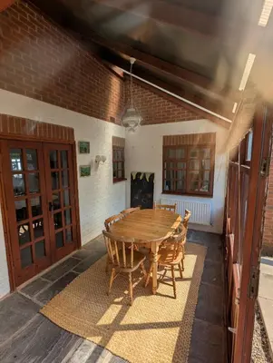 a dining room with a wooden table and chairs at Breidden Annexe in Four Crosses