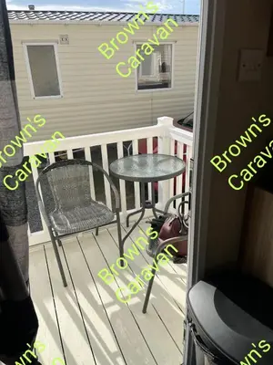 a balcony with a table and a chair on a porch at Browns 137 Snowdon Summit 099 in Barmouth