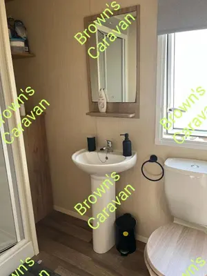 a bathroom with a sink and a mirror and a toilet at Browns 137 Snowdon Summit 099 in Barmouth