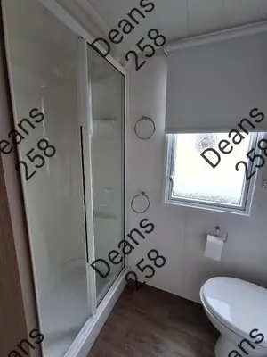 a bathroom with a shower and a toilet and a window at Deans Snowdon Summit 109 in Barmouth
