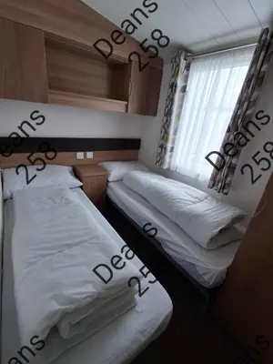 two beds in a small room with a window at Deans Snowdon Summit 109 in Barmouth