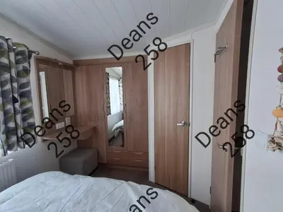 a bedroom with a bed and a door with the word exam at Deans Snowdon Summit 109 in Barmouth