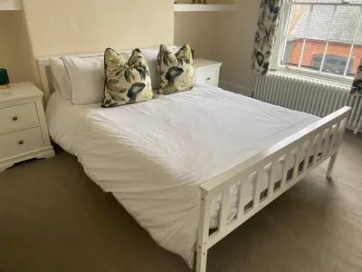 a white bed with pillows on it in a bedroom at Town centre Victorian period 3 bedroom home in Bishops Castle