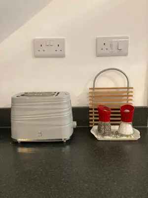a counter with a toaster and two containers on it at Ludford View, riverside cottage in Ludlow with private parking in Ludlow