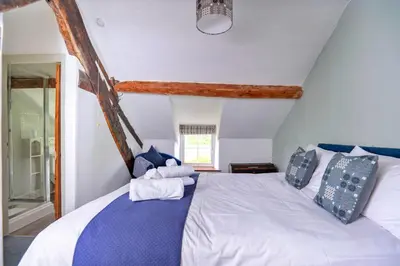 a bedroom with a bed with blue and white pillows at Finest Retreats - Penclogwynau in Dolgellau