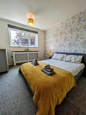 a bedroom with a bed with two towels on it at Your Leominster Base - 3BR Home with Garden & Parking in Leominster