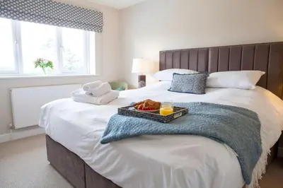 a bed with a tray of food on top of it at Wellingtonia Cottage in Chirbury