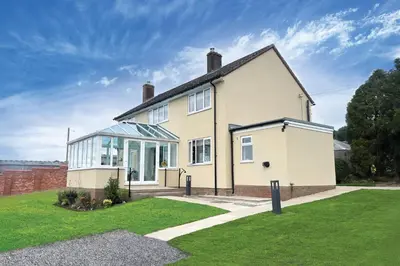 a white house with a lot of windows at Wellingtonia Cottage in Chirbury