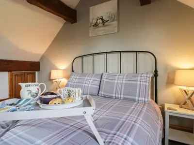 a bed with a tray of food on top of it at Cyffdy Cottage - Aran in Bala
