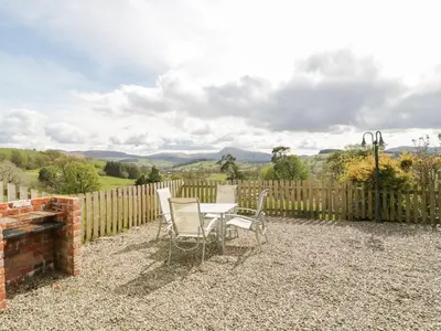 a patio with a table and chairs and a fence at Cyffdy Cottage - Aran in Bala