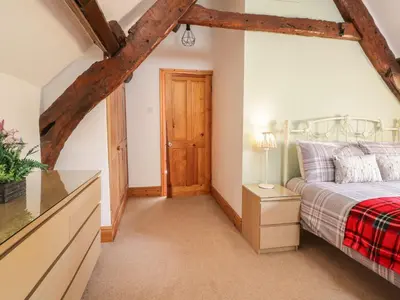 a bedroom with a bed and a dresser and a door at Cyffdy Cottage - Tegid in Bala