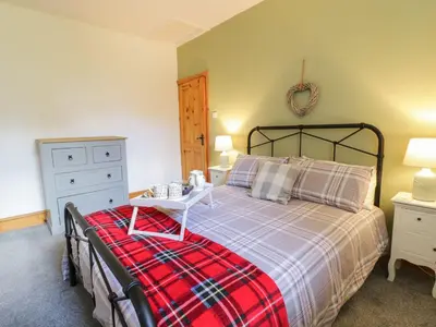 a bedroom with a bed with a table on it at Cyffdy Cottage - Arenig in Bala
