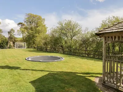 a trampoline in a yard with a gazebo at Cyffdy Cottage - Arenig in Bala