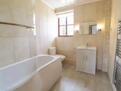 a bathroom with a tub and a toilet and a sink at Cyffdy Cottage - Arenig in Bala