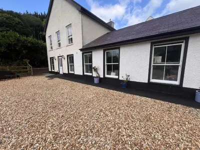 a house with a gravel driveway in front of it at Cilgwyn Manor in Myddfai