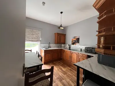 a large kitchen with wooden cabinets and a table at Cilgwyn Manor in Myddfai