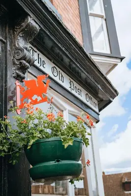 a potted plant hanging on the side of a building at Old Post Office in Talgarth