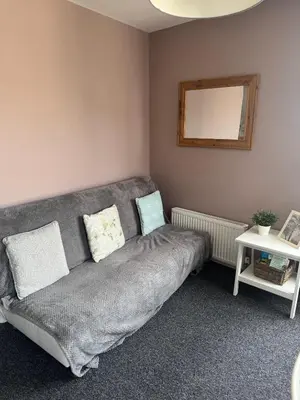 a living room with a couch and a mirror at Old Post Office in Talgarth