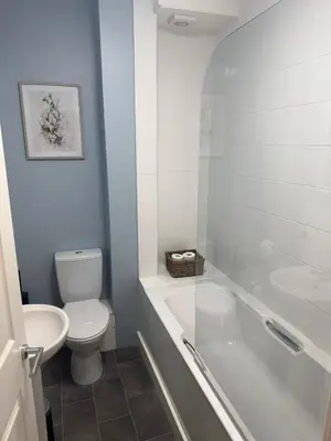 a bathroom with a toilet and a tub and a sink at Old Post Office in Talgarth