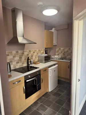 a kitchen with a sink and a stove top oven at Old Post Office in Talgarth