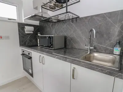 a kitchen with a sink and a microwave at Rydlan in Aberystwyth