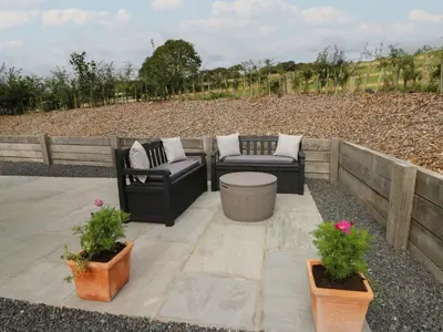 a patio with two chairs and potted plants at Rydlan in Aberystwyth