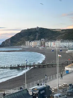 a view of a beach with buildings and the ocean at two bed Seafront apartment - sea views in Aberystwyth