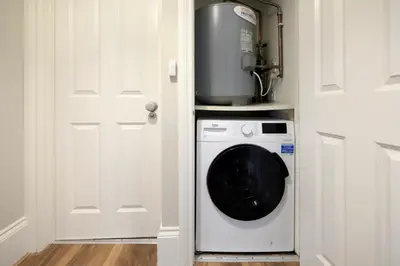 a washer and dryer in a kitchen with a door at two bed Seafront apartment - sea views in Aberystwyth