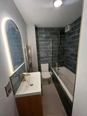 a bathroom with a sink and a tub and a toilet at two bed Seafront apartment - sea views in Aberystwyth