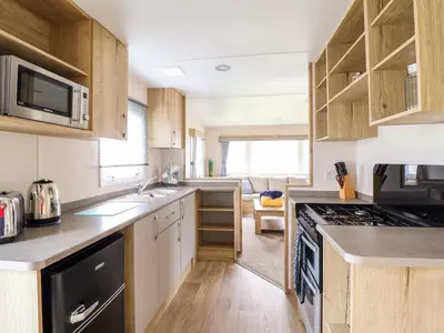 a kitchen with a sink and a stove top oven at Beachcombers Barmouth Bay Holiday Park in Talybont