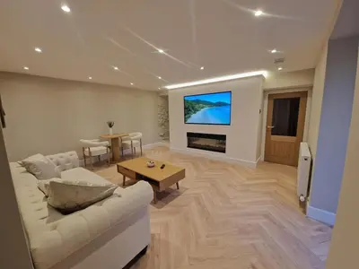 a living room with a white couch and a tv at Modern Retreat near Aberaeron - Luxe 1 bed Escape in Ciliau-Aeron