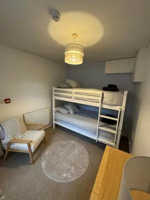 a small room with a bunk bed and a chair at Glyder Flat - North Wales in Dolgellau