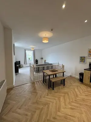 a living room with a table and a wooden floor at Glyder Flat - North Wales in Dolgellau