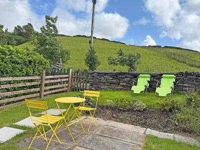 four chairs and a table and chairs in a yard at Tegfryn Cottage in Tanygrisiau