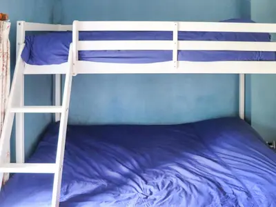 a bunk bed with purple sheets and a blue wall at Farm House - Uk50262 in Llandeilo
