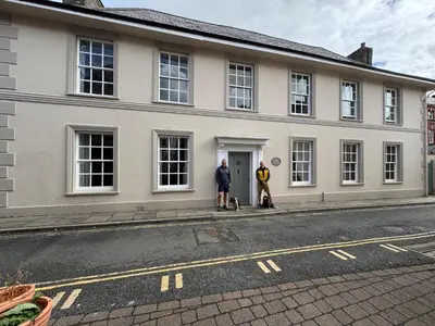 two people standing in front of a white house at Cantre Selyf in Brecon