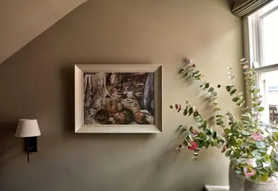 a painting on a wall with a vase of flowers at Castle Corner, The Georgian House in Ludlow